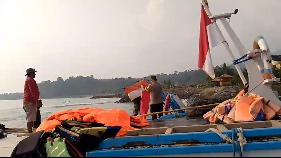 Aipda Deni Meydistira memasang bendera merah putih baru di kapal penyeberangan.